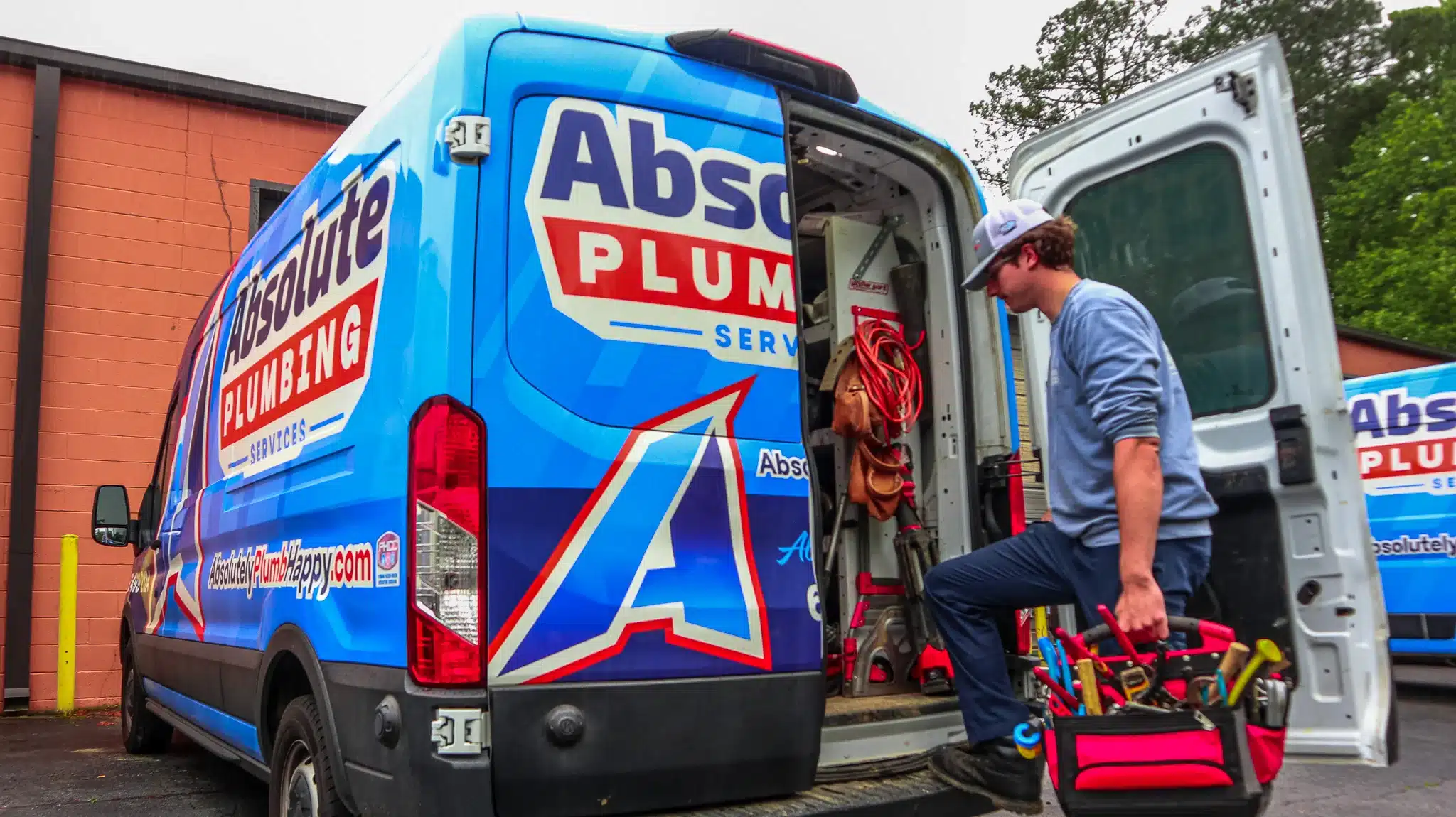Plumber unloading tools from an Absolute Plumbing Services van in Acworth, GA