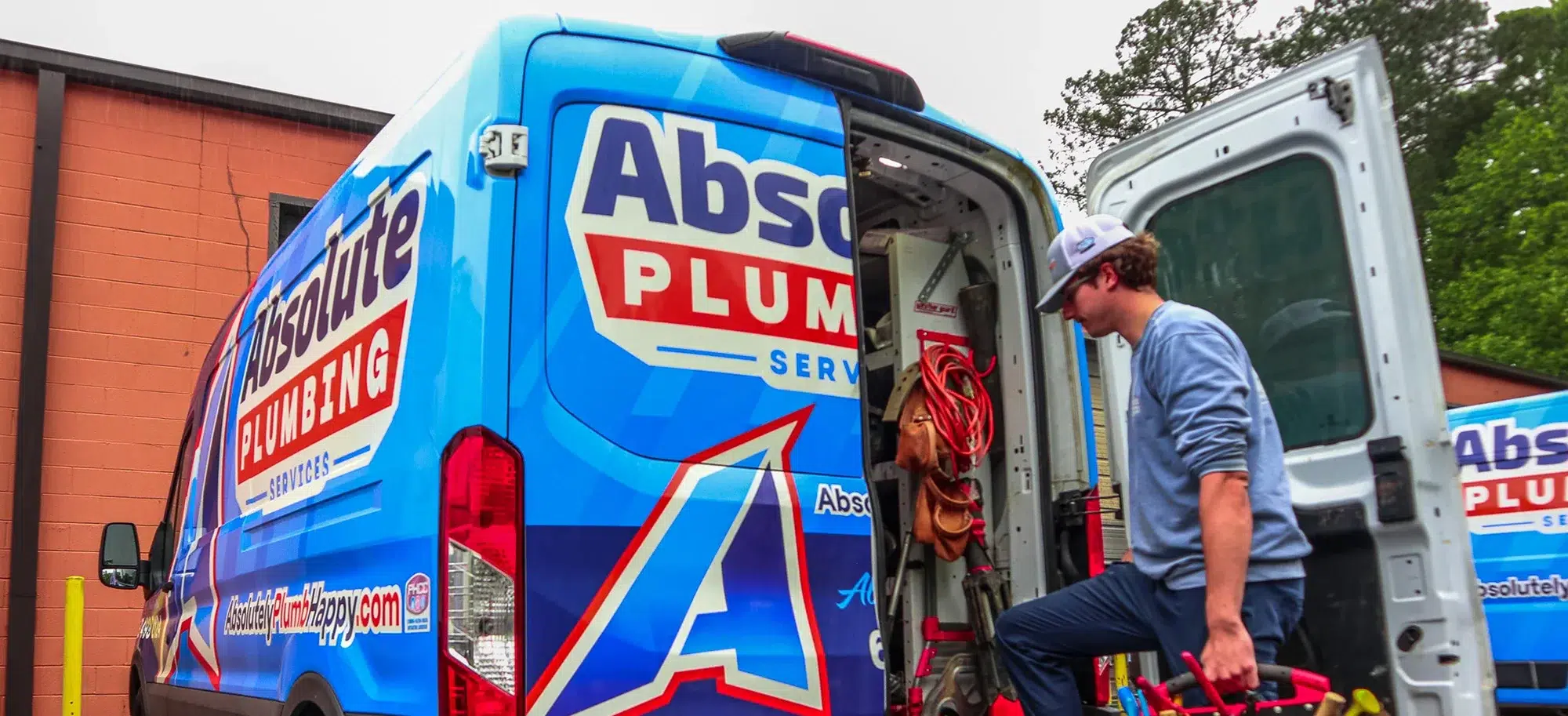 cartersville plumbing tech looking in the back of an Absolute Plumbing Van to select the right equipment for plumbing repairs