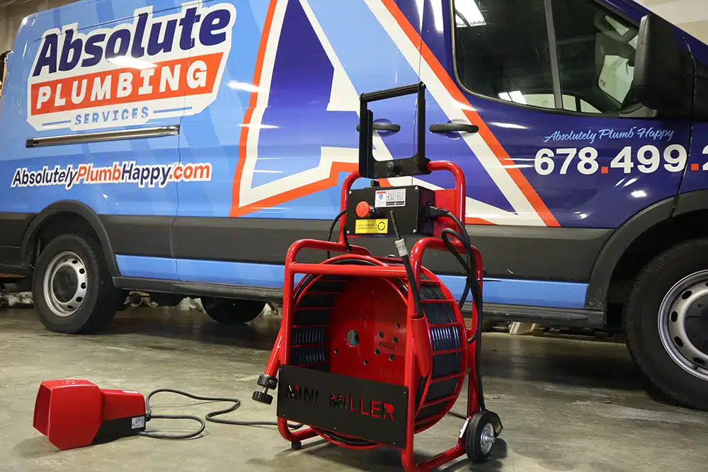 Picote Mini Miller drain cleaning, descaler, and root removal in front of a Absolute Plumbing van