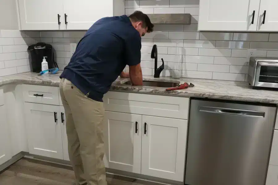 Plumber cleaning kitchen sink drains in Acworth, GA