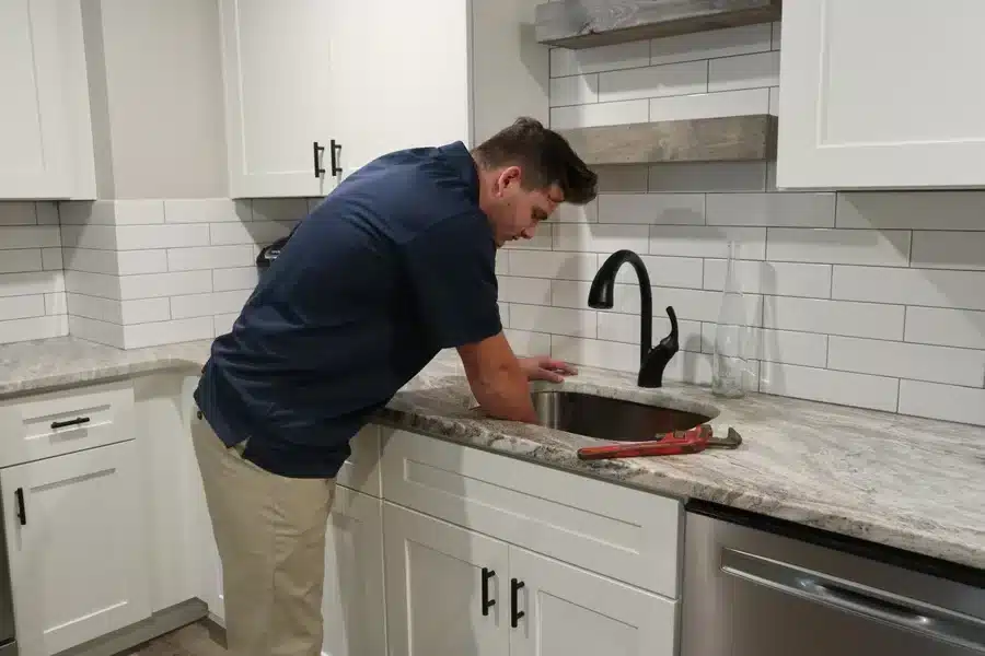 Plumber repairing a kitchen sink faucet in Acworth, GA