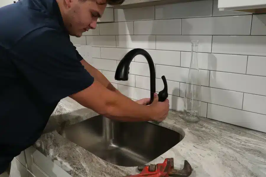 Plumber installing a kitchen faucet in Acworth, GA