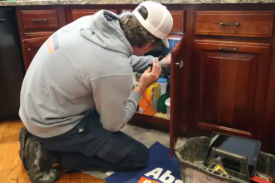 Plumber fixing a leak under kitchen sink in Acworth, GA