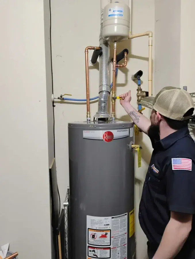 Absolute Plumbing Services technician maintaining a Water Heater in Acworth, GA