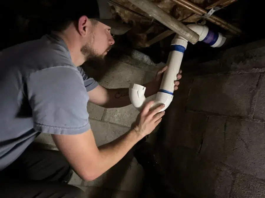 Absolute Plumbing services technician performing drain maintenance in a residential home in Acworth, GA